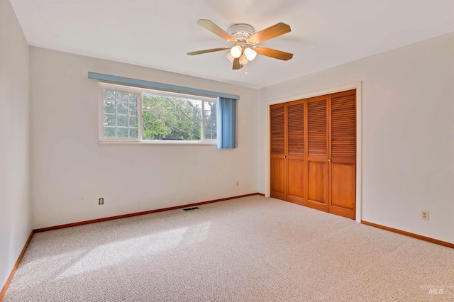 unfurnished bedroom with a ceiling fan, baseboards, carpet, and a closet