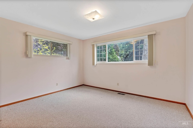 carpeted spare room with baseboards and visible vents