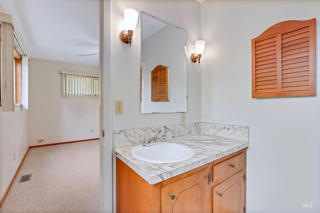 bathroom featuring visible vents, baseboards, and vanity