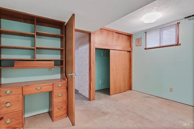 unfurnished bedroom with visible vents, concrete floors, and a closet