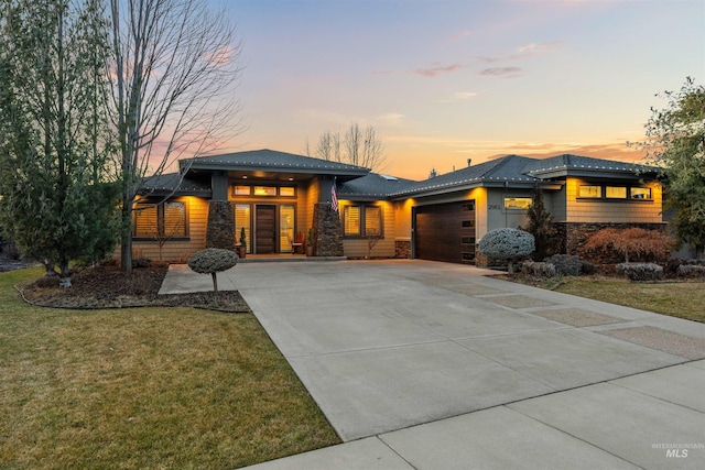 prairie-style house with a garage and a yard