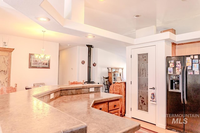 12 Blue Spruce Ct, Cascade, ID 83611 - kitchen with black refrigerator with ice dispenser, recessed lighting, decorative light fixtures, light countertops, and a chandelier