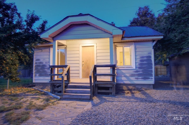 view of front of house featuring fence and metal roof