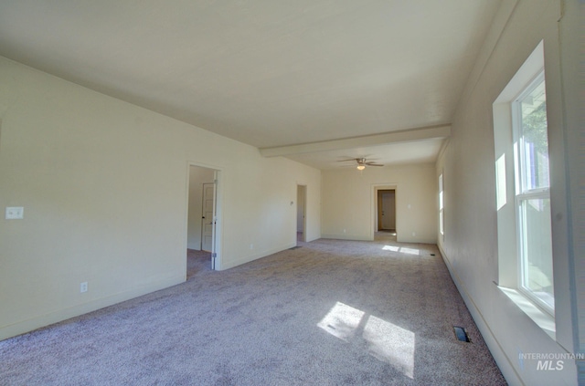 carpeted empty room featuring a ceiling fan and baseboards