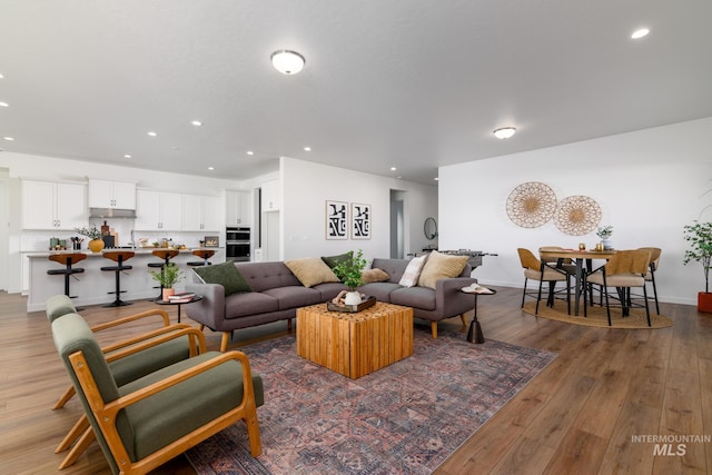 living room with recessed lighting, wood finished floors, and baseboards