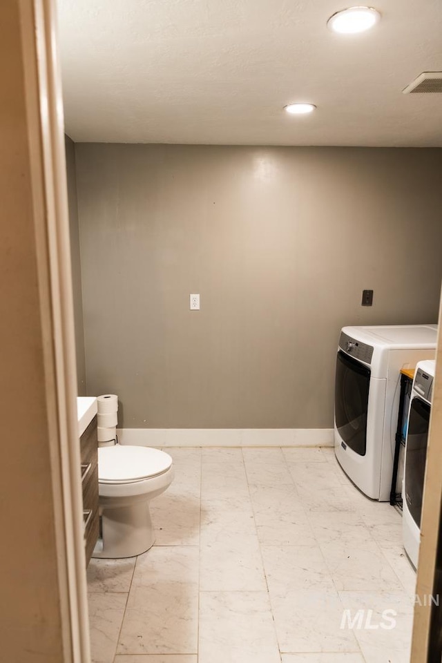 laundry room with baseboards, laundry area, washer / dryer, recessed lighting, and marble finish floor