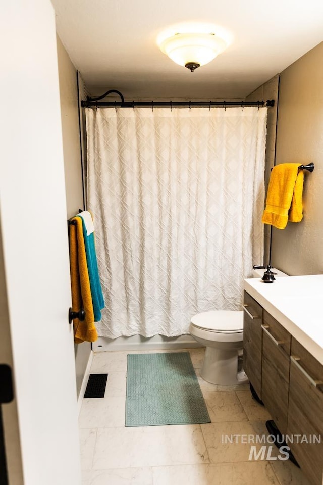 full bath featuring shower / bath combo with shower curtain, visible vents, toilet, and vanity