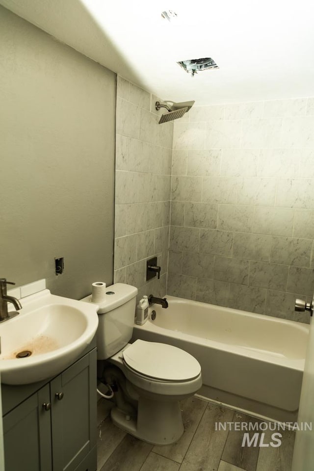 full bath featuring toilet, vanity, bathing tub / shower combination, and wood finish floors