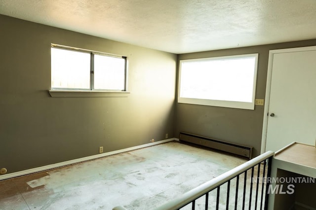 empty room featuring a textured ceiling and a baseboard radiator