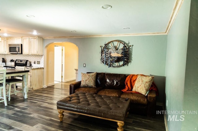 living room with recessed lighting, arched walkways, dark wood-style floors, and crown molding