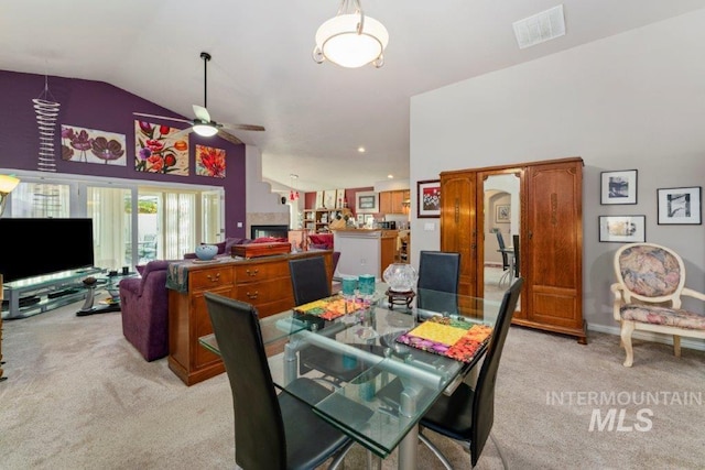 carpeted dining room featuring ceiling fan and lofted ceiling