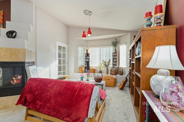 living room with lofted ceiling, light carpet, and a tile fireplace