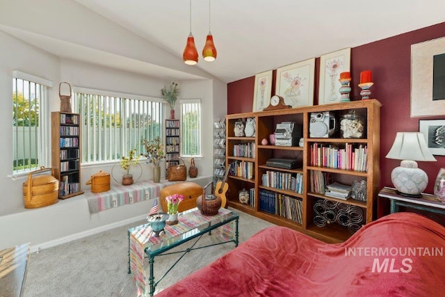 sitting room with a wealth of natural light, lofted ceiling, carpet, and an inviting chandelier