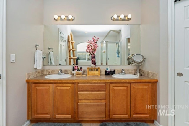 bathroom featuring a shower with door and vanity