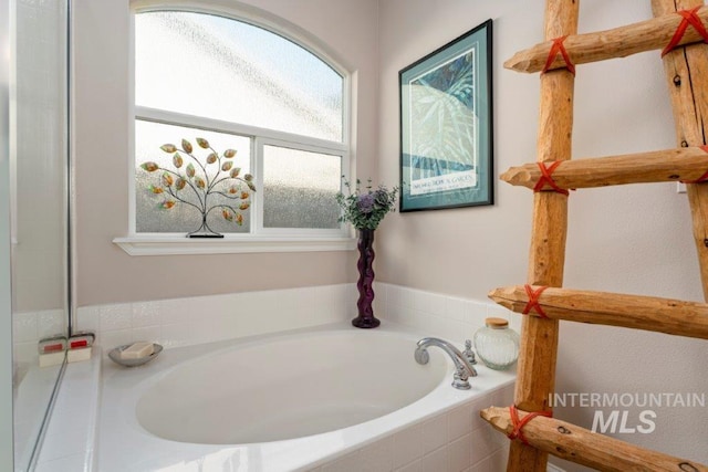 bathroom with a relaxing tiled tub