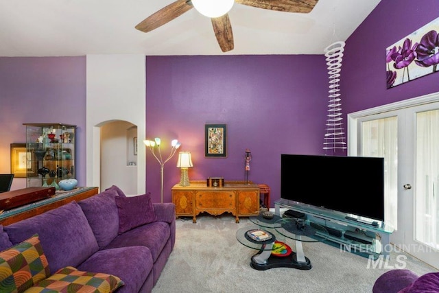 carpeted living room with a high ceiling and ceiling fan