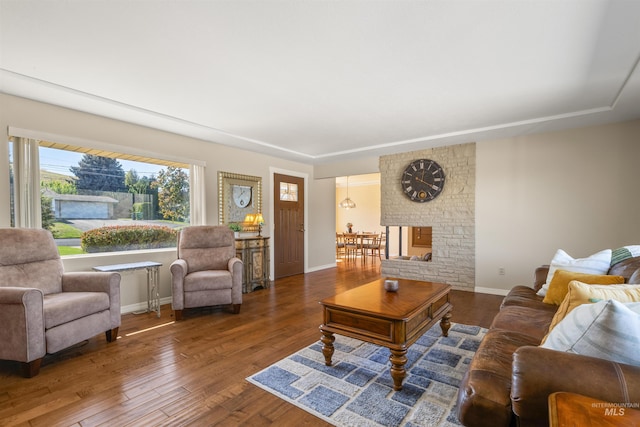 living room with a fireplace and dark wood-type flooring