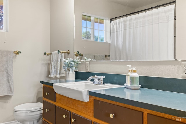 bathroom featuring vanity, curtained shower, and toilet