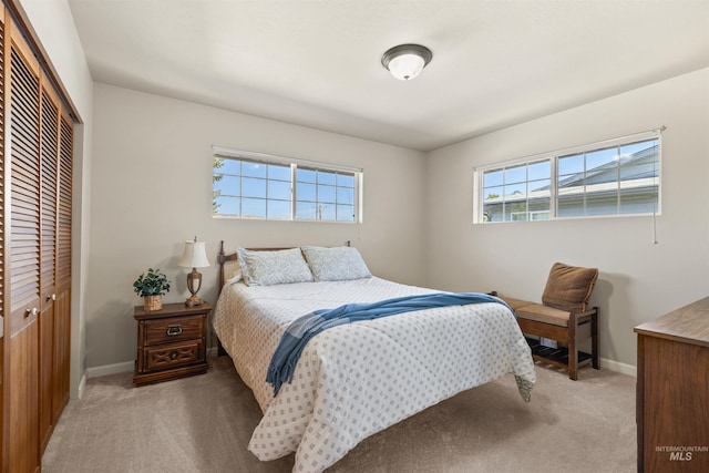 bedroom featuring light colored carpet and a closet