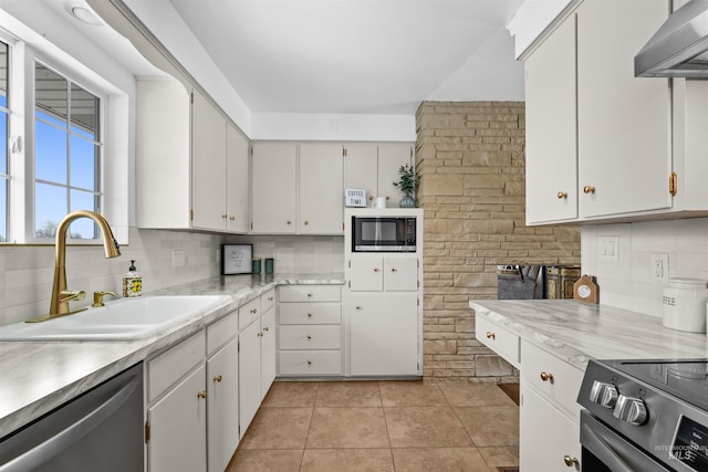 kitchen with sink, ventilation hood, white cabinets, and appliances with stainless steel finishes