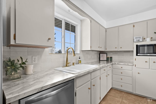 kitchen with light tile patterned flooring, white cabinetry, sink, backsplash, and stainless steel appliances