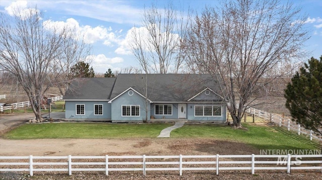 ranch-style house with a fenced front yard and a front lawn