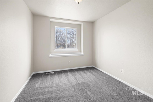 carpeted spare room with baseboards and visible vents