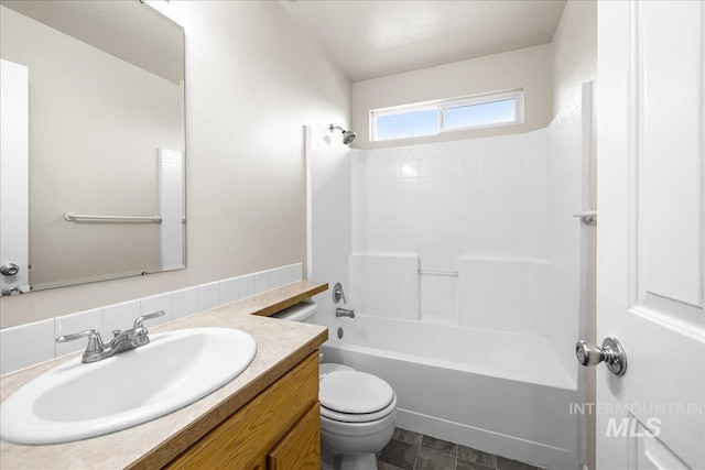 bathroom featuring washtub / shower combination, toilet, and vanity