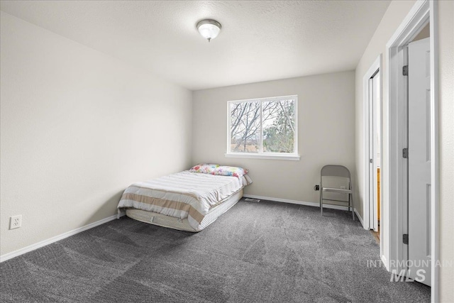 bedroom with baseboards and dark carpet