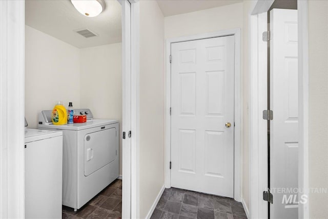 clothes washing area with visible vents, stone finish flooring, baseboards, laundry area, and independent washer and dryer