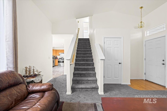 entryway featuring stairway, high vaulted ceiling, baseboards, and carpet floors