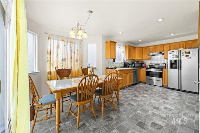 dining space with recessed lighting, a wealth of natural light, and a chandelier