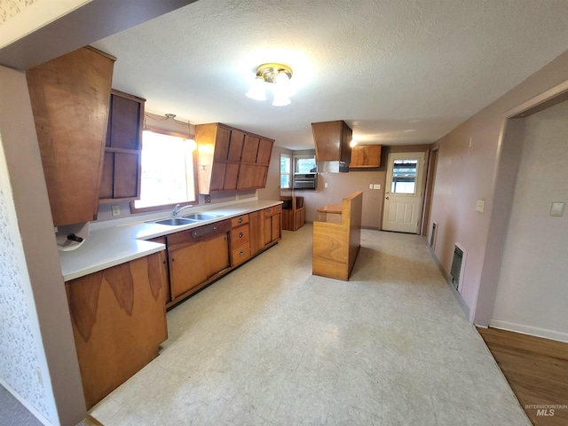 kitchen with a textured ceiling, sink, decorative light fixtures, and custom exhaust hood