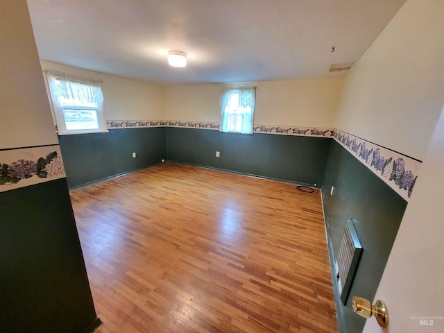 spare room featuring hardwood / wood-style flooring and a wealth of natural light