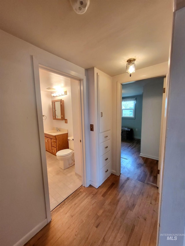 hallway featuring light hardwood / wood-style floors and sink