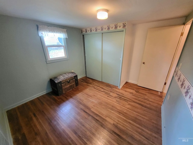 unfurnished bedroom with a closet and hardwood / wood-style floors