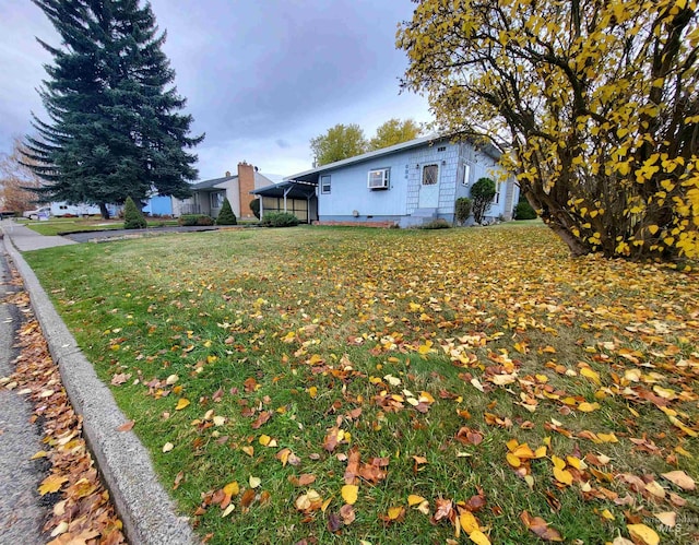 view of yard featuring a carport and a wall unit AC