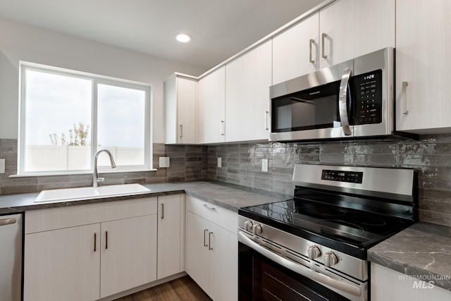 kitchen featuring sink, white cabinets, appliances with stainless steel finishes, and decorative backsplash