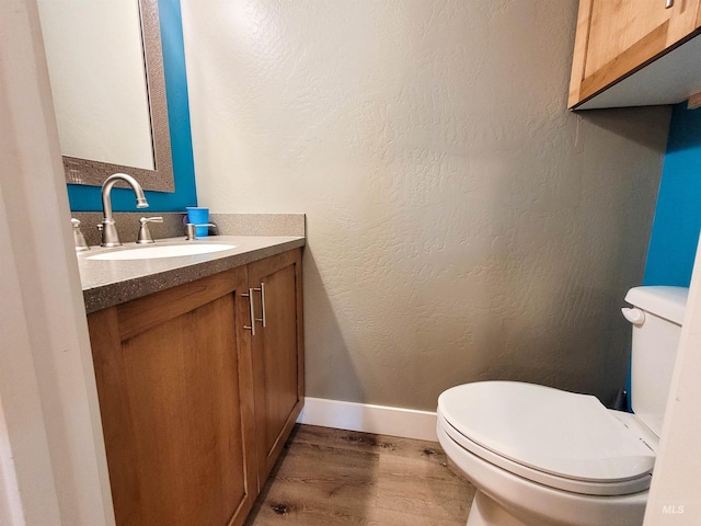 bathroom with hardwood / wood-style floors, vanity, and toilet