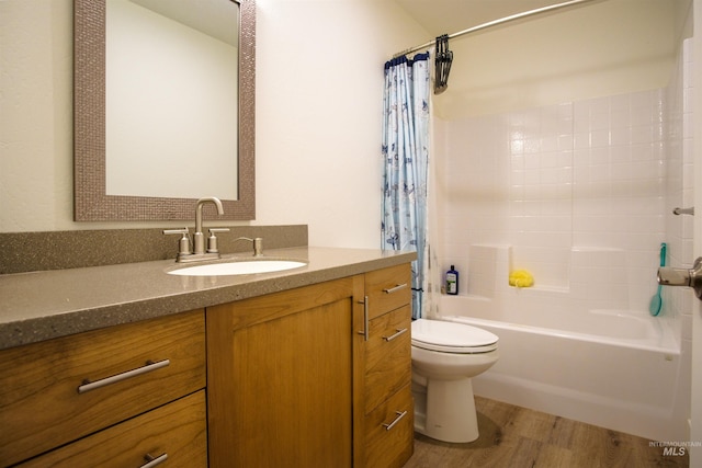 full bathroom featuring shower / bath combo with shower curtain, hardwood / wood-style flooring, vanity, and toilet