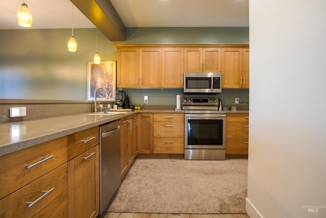 kitchen featuring light stone counters, sink, light carpet, stainless steel appliances, and decorative light fixtures