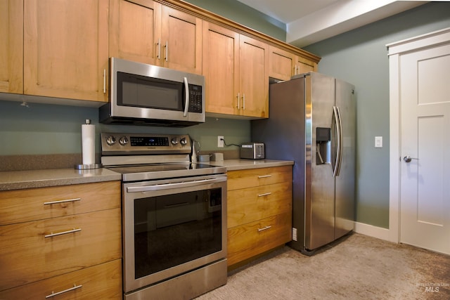 kitchen with stainless steel appliances and light colored carpet