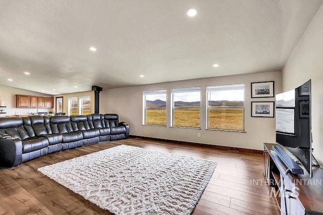 living room featuring recessed lighting, baseboards, plenty of natural light, and hardwood / wood-style flooring