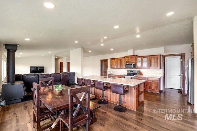 dining area with recessed lighting, a wood stove, and dark wood-style flooring