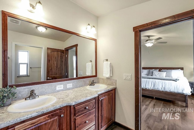full bath featuring visible vents, a sink, ensuite bathroom, and double vanity