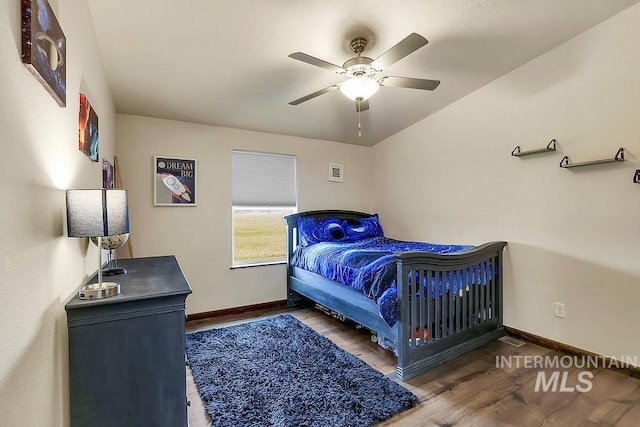 bedroom with a ceiling fan, baseboards, and wood finished floors