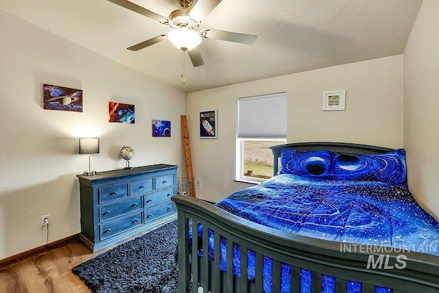 bedroom featuring baseboards, ceiling fan, and wood finished floors