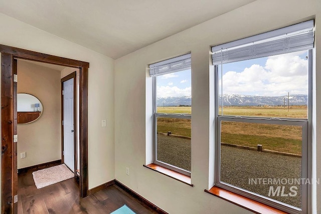 entryway with baseboards, a mountain view, dark wood-style floors, and lofted ceiling