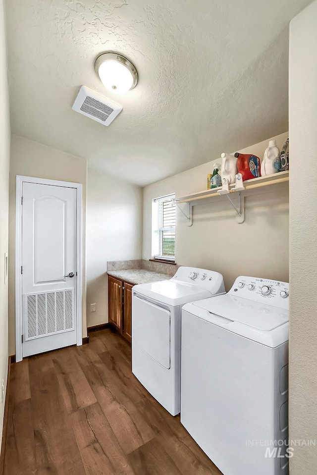 laundry area featuring visible vents, cabinet space, separate washer and dryer, and dark wood-style floors