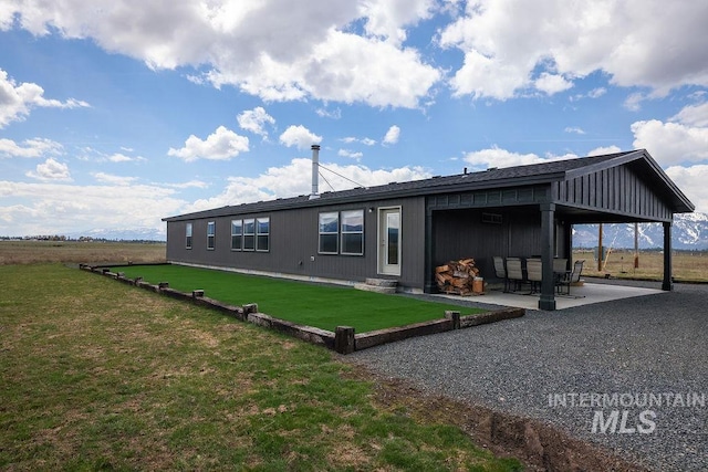 back of property featuring a lawn and a patio area